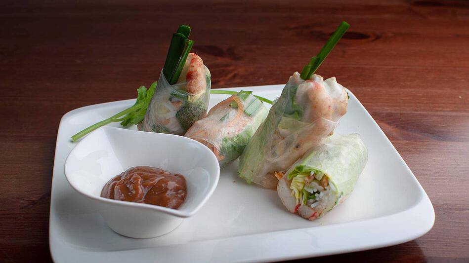 dos rollos de verano vietnamitas servidos con verduras y salsa de maní