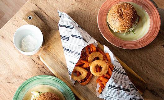 Vegan burger with fried onion rings and sweet potatoes