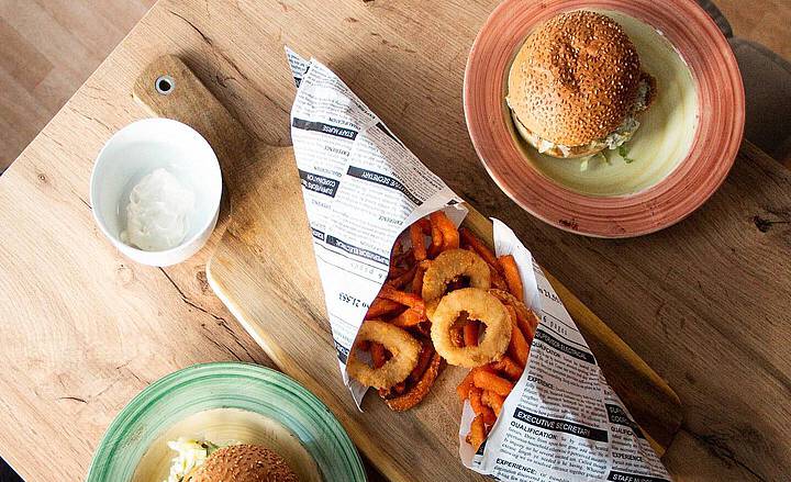 Vegan burger with fried onion rings and sweet potatoes